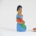 Kneeling Muñeca in Blue Dress with Carrots and Plate of Carrots